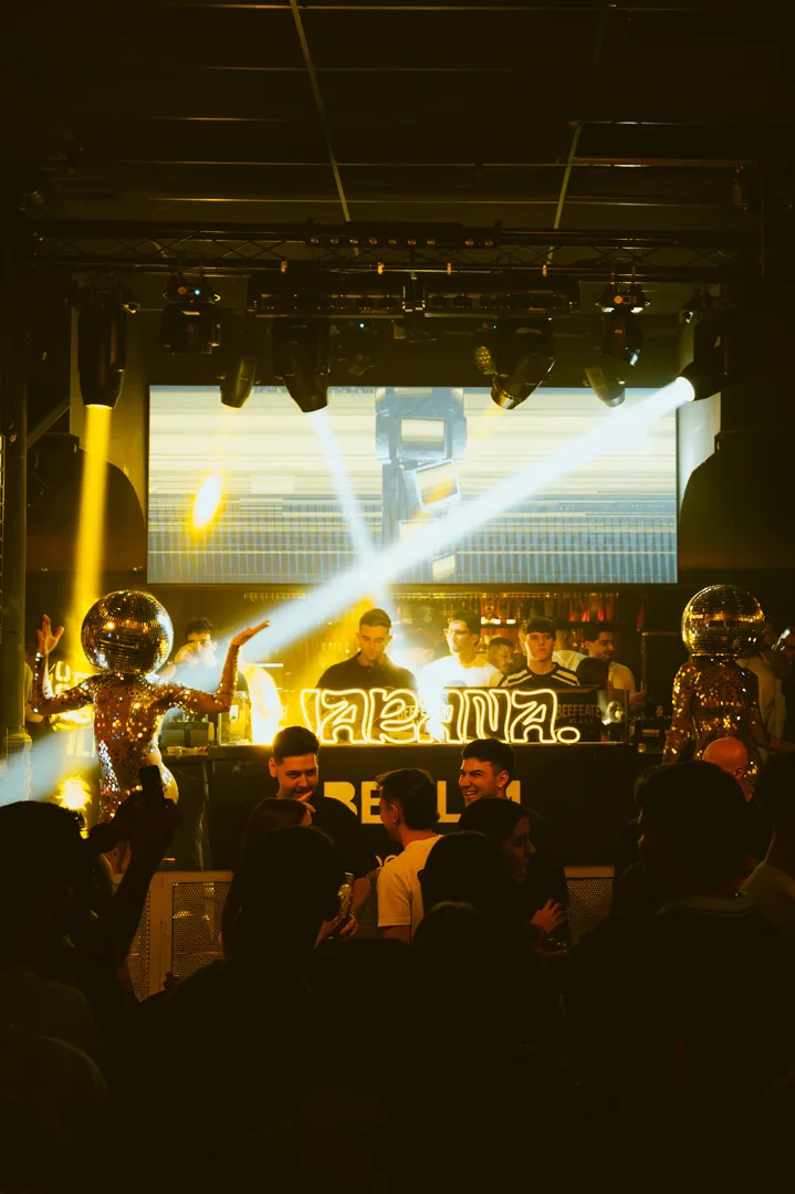 Escenario de Berlin Social Club con la cabina de JARANA y dos bailarinas con cabeza de bola de espejos.